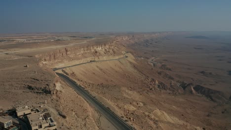 Mitzpe-Ramon-Mitzperamon-Israel-Negev-desert-highway-drone-dolly-in-flying-car-road-mountains-sand-middle-east-middleast-jordan-palestine-crater-Ramon-buildings-stones-stone