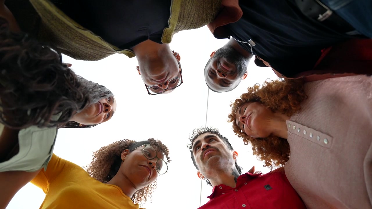 Grupo Diverso de Amigos em Círculo Olhando para Baixo