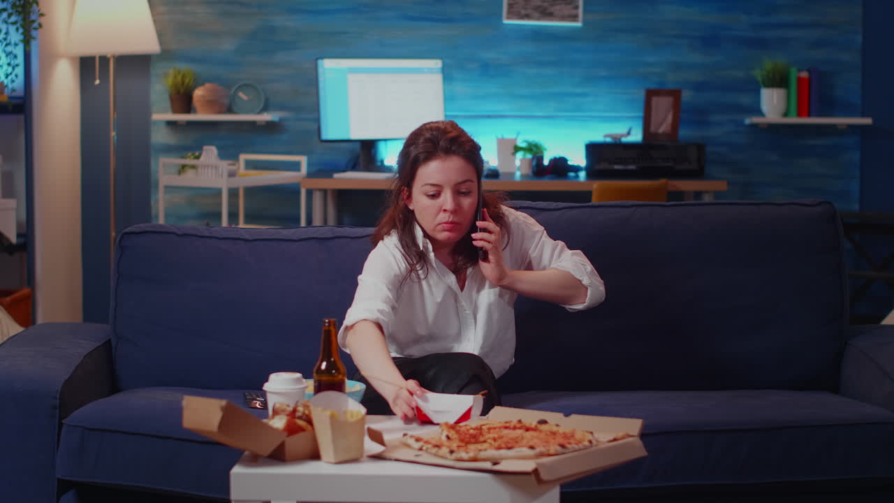 Young person eating chinese food answering phone call