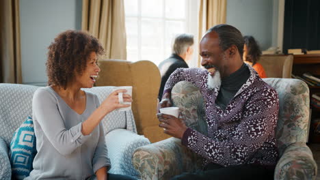 Middle-Aged-Couple-Sitting-Around-Table-In-Coffee-Shop