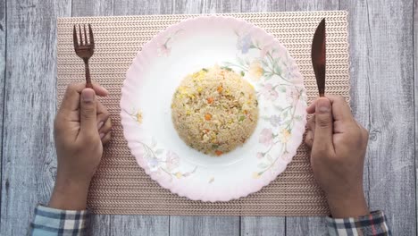 arroz frito en un plato con tenedor y cuchillo