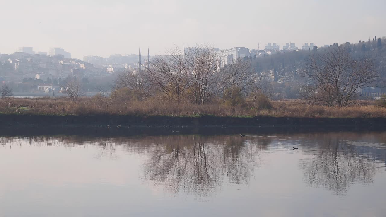 Istanbul cityscape reflected in a calm river on a foggy winter day