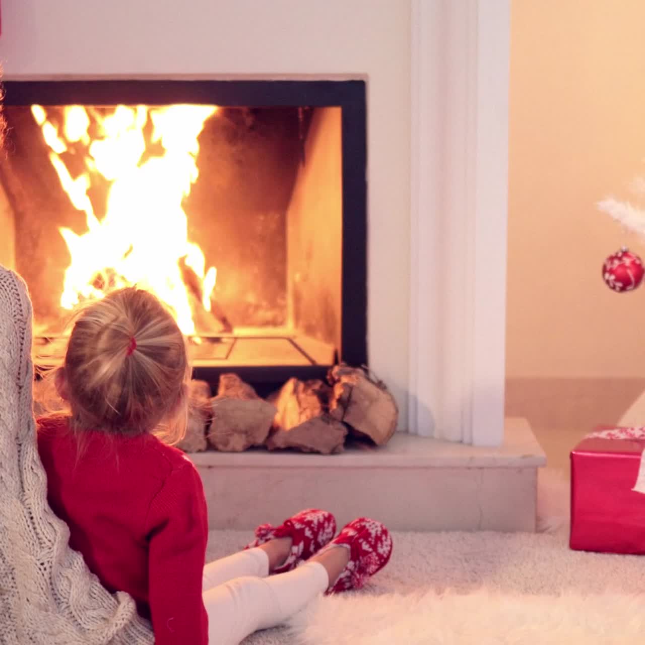 벽난로 옆에서 몸을 녹이는 엄마와 아이