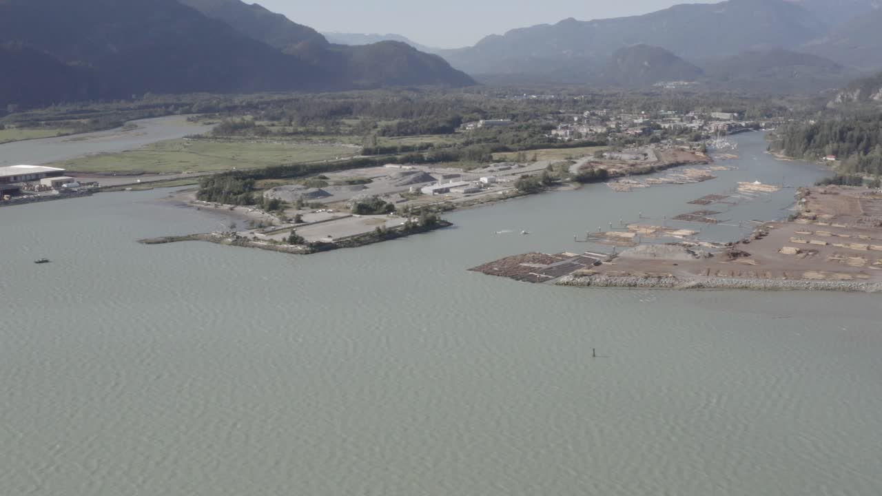vuelo aéreo sobre el puerto de la bahía mineral del océano de la industria maderera muelle de exportación de inventario apilado para la preparación para abordar remolcadores al puerto de transporte de carga en un día claro de verano 2-4