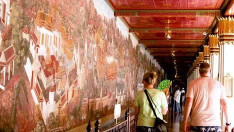 visitors admire temple wall paintings in bangkok