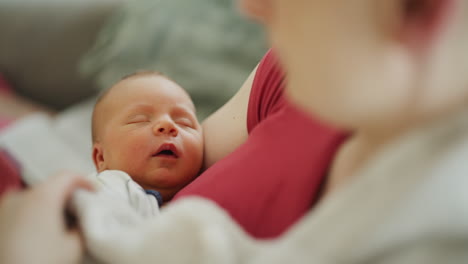 close-up of newborn baby face with mother's embrace