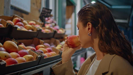 girl picking fresh fruits from shelf street market at evening close up.