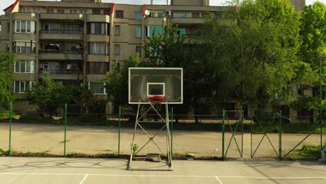 forward aerial footage of empty basketball field in the neighborhood