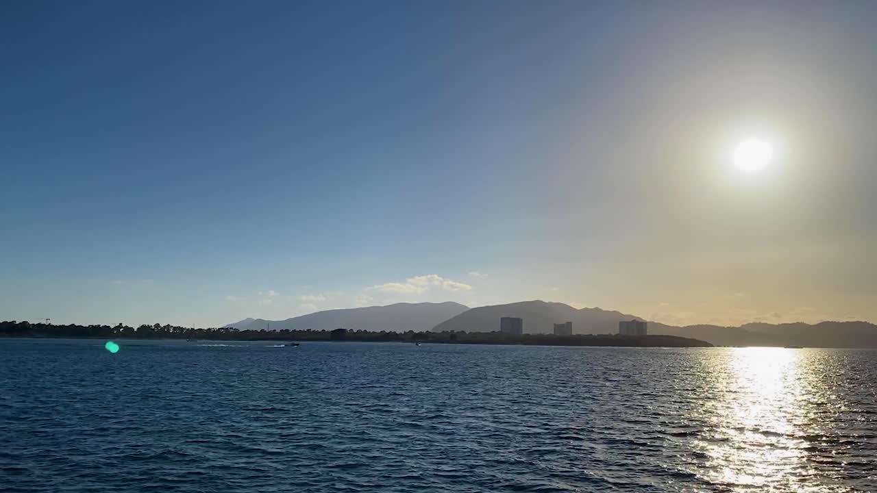 느린 동작으로 배경에 arrabida가 있는 보트에서 고르지 못한 바다 위로 일몰을 볼 수 있습니다.