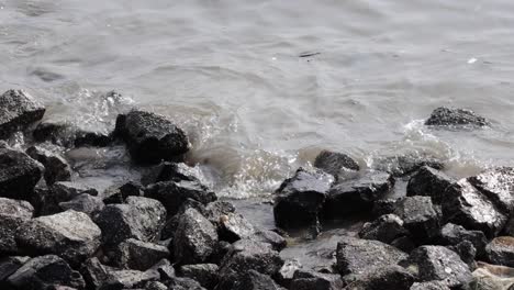 small sea waves crushing to the rocky shore