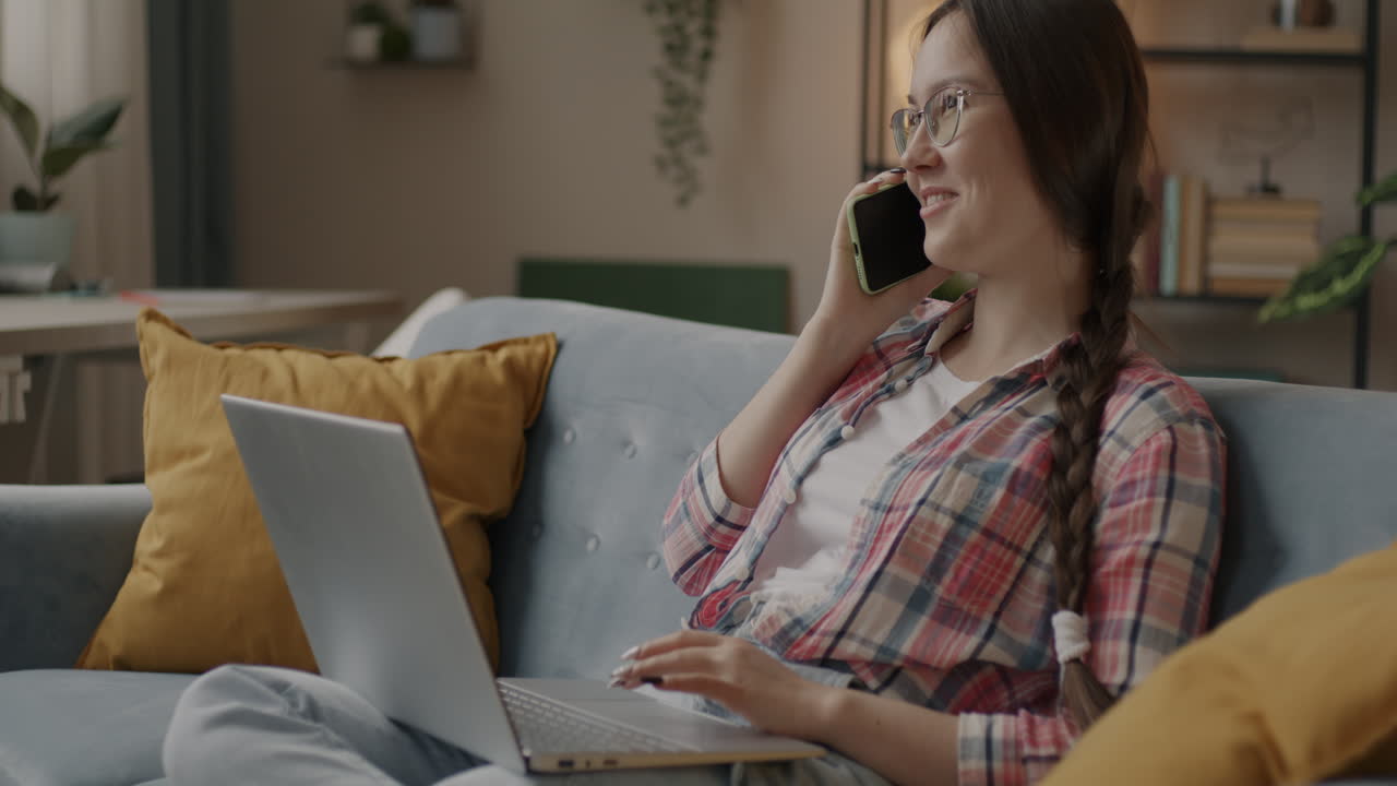 Young Woman on Laptop Talking on Phone