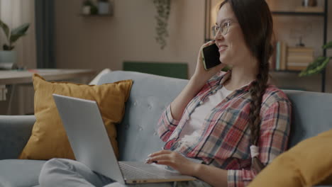 Young Woman on Laptop Talking on Phone