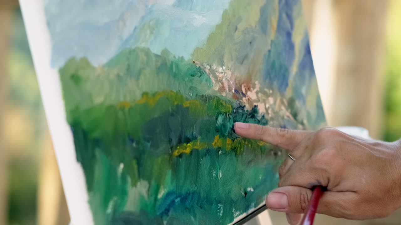 Personne montrant un tableau de montagnes et d'arbres