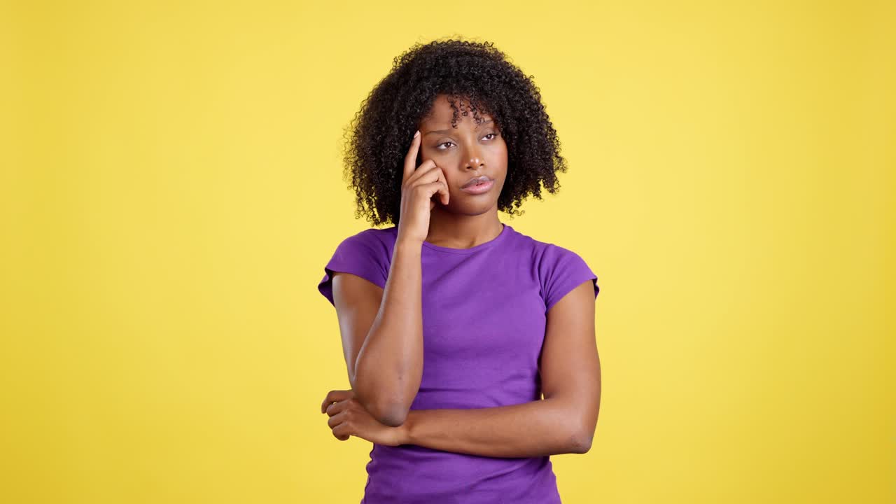 Woman Deep in Thought or Concentration Against Yellow Background