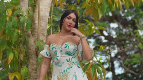 light skin woman stands in a park wearing a short dress