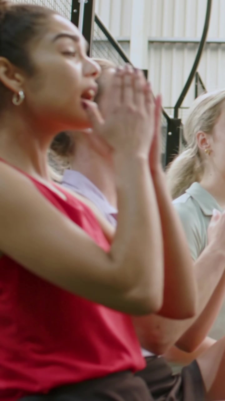 Vertical video: Shouting red woman cupping mouth, calling on stands at off-screen play, copy space