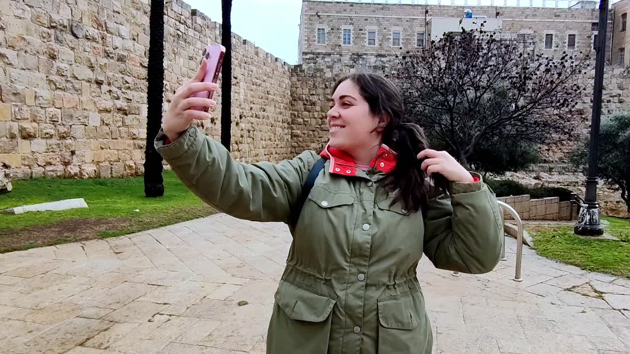 woman taking a selfie near historic stone walls