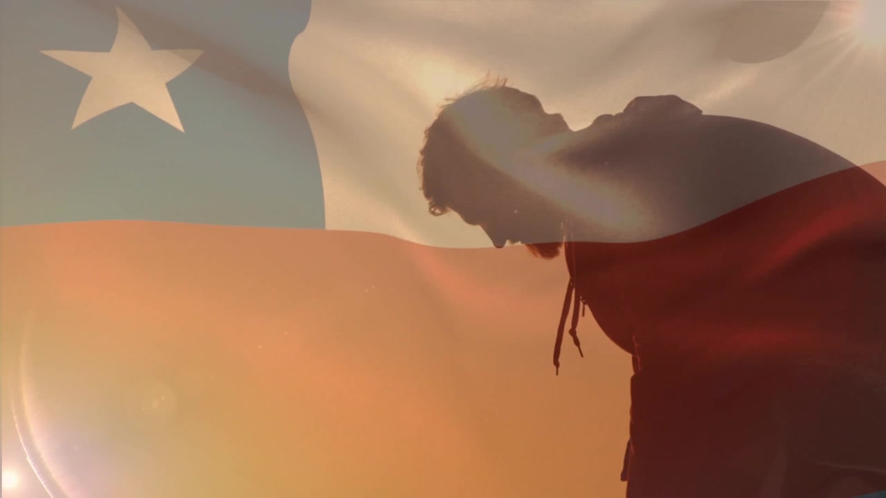 Animazione di una bandiera cilena che sventola contro la silhouette di un uomo sulla spiaggia.