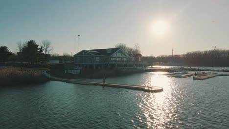 drone footage of a person walking across a lake dock at sunset