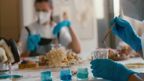 people painting with resin and brushes
