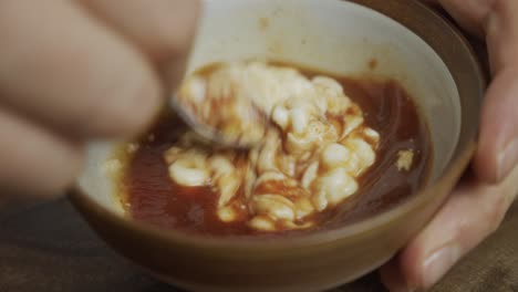 mixing cheeseburger sauce in small bowl by hand with spoon