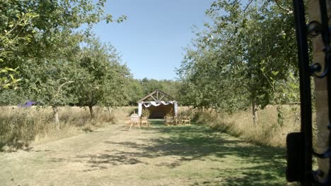 Shot-trough-the-gates-revealing-a-wedding-ceremony-setup-with-a-helicopter-in-the-background