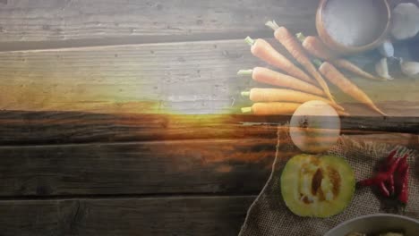 Animation-of-landscape-over-vegetables-on-wooden-background