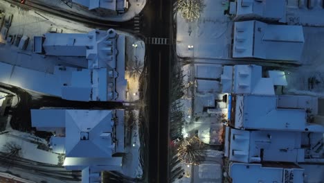 snow covered town houses lining main street with quaint christmas decorations and lights