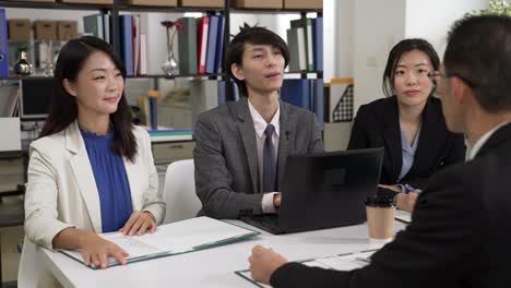 selective focus of group of startup businesspeople closing successful deal with handshake at business meeting. female colleagues clapping hands cheering for good result