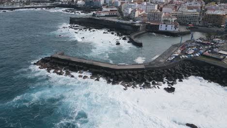 Overhead-Aufnahme-Von-Wellen,-Die-Auf-Einem-Langen-Pier-Mit-Felsen-Krachen,-Puerto-De-La-Cruz,-Spanien