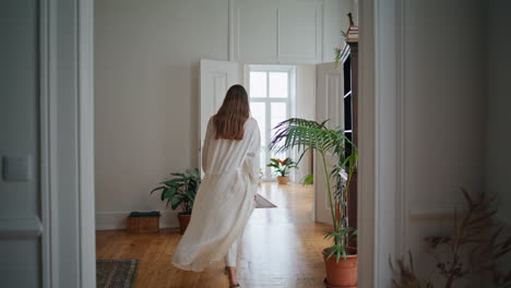 young lady opening doors at morning interior. relaxed girl walking at cozy home