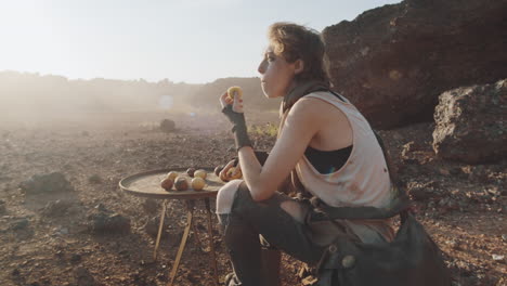 mujer comiendo manzanas en un mundo post-apocalíptico