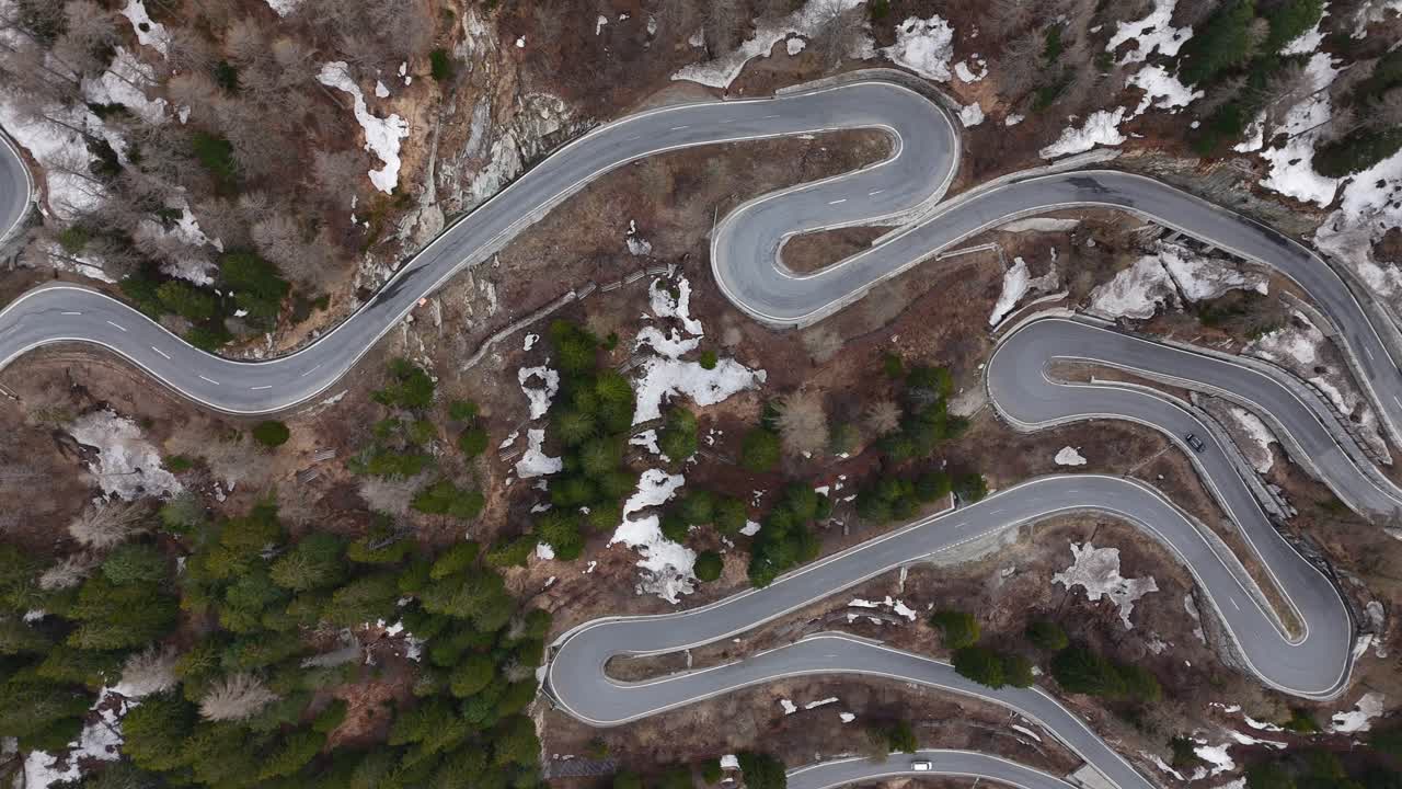 coche conduciendo a lo largo de la curva carretera serpentina en el paso alpino de la montaña maloja, suiza