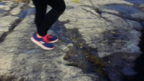 camera-following-the-step-of-a-woman,-walking-on-a-trail-in-table-mountain