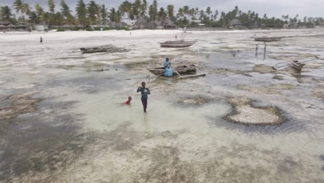 drone shot of young black african boys fishing on coast of tanzania