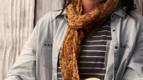 hipster playing guitar against wooden fence