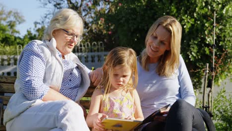 multi-generation family looking at photo album in garden 4k