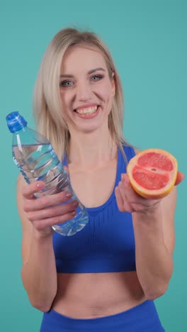 woman with water bottle and grapefruit