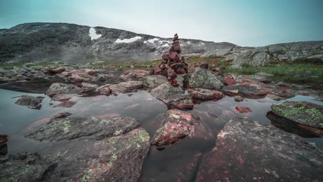 mysterious stone cairns on the bank of the shallow pond on the mountainous plateau