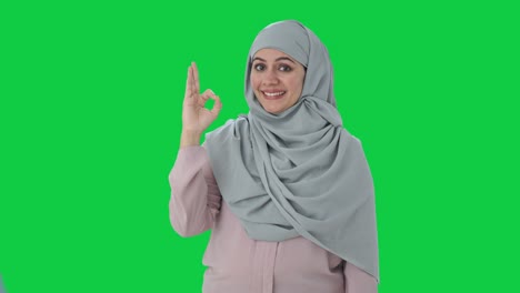 happy muslim businesswoman showing okay sign green screen