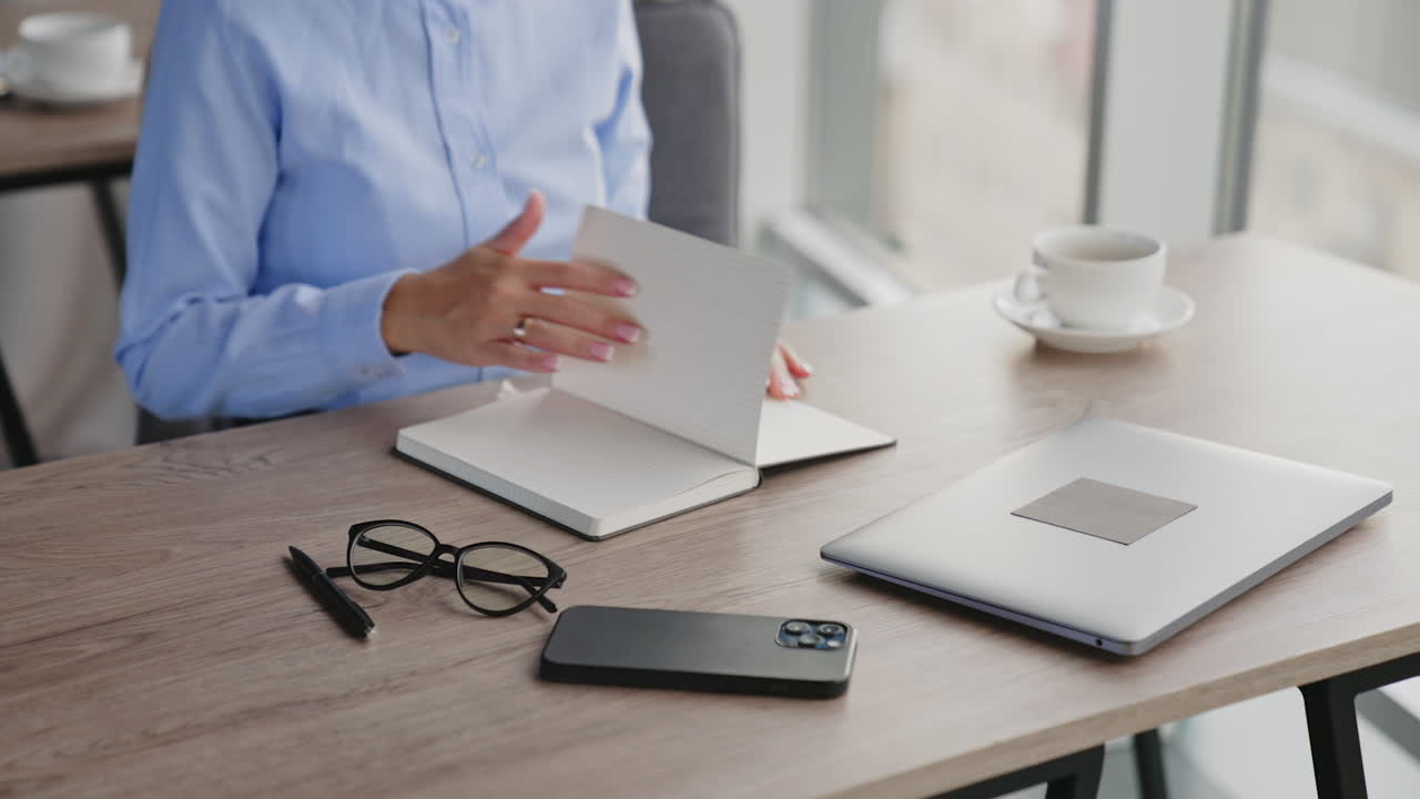 Woman working at a desk with a laptop and notebook