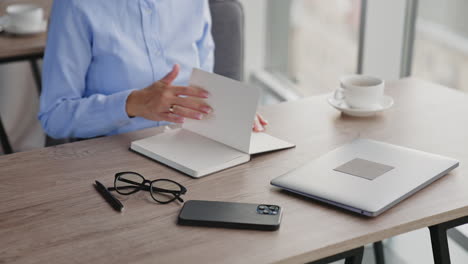 woman working at a desk with a laptop and notebook