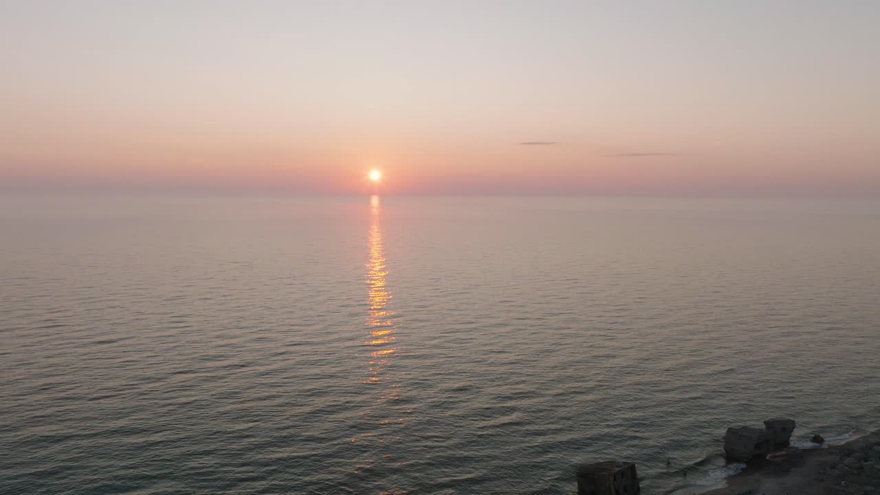 평온한 발트해 위의 활기찬 높은 대조적인 일몰의 아름다운 공중 전망, 지평선에 구름, 카로스타 전쟁 항구 콘크리트 해안 요새 폐허 리파자, 넓은 드론  ⁇  앞으로 이동