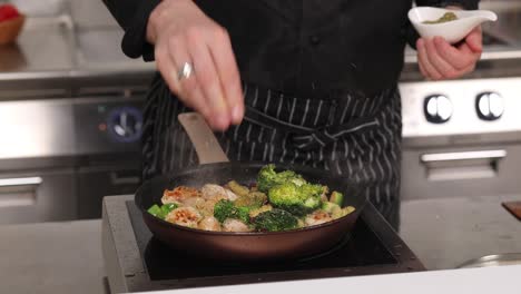 chef seasoning chicken and vegetables