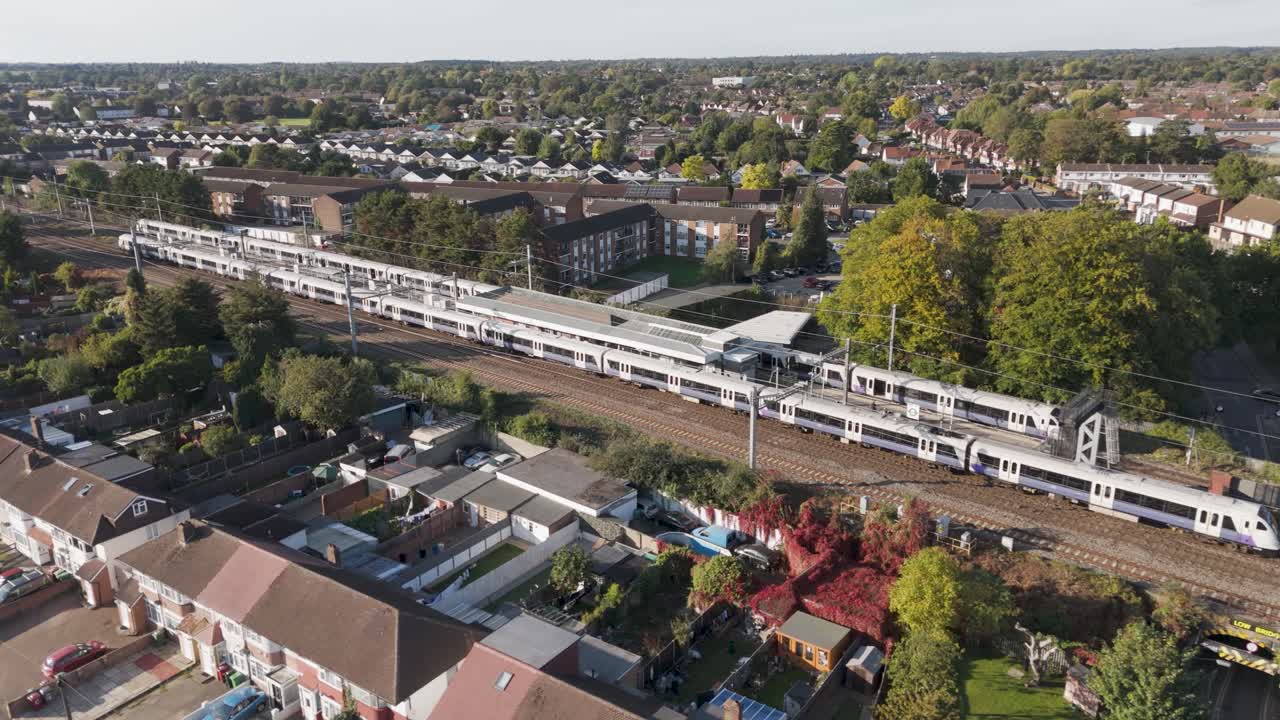 Elizabeth line trains stationed at platforms with passenger facilities and surrounding residential areas at Burnham station complex in Slough, Berkshire