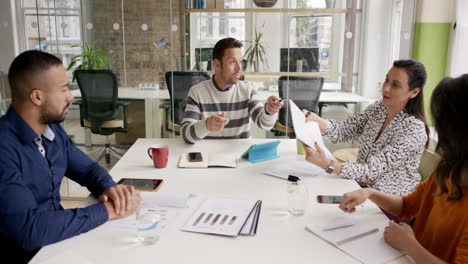 a confident and attractive business team of mixed ages and ethnicity are holding a meeting in a light, modern office building. they are discussing ideas for their business development.