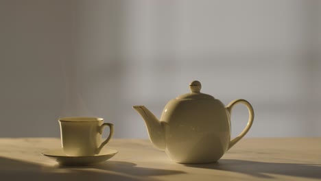 studio shot of making traditional british cup of tea using teapot 4