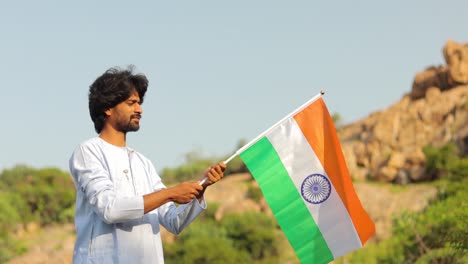 The-young-man-with-traditional-Indian-dress-holding-Indian-Flag-on-a-sunny-day