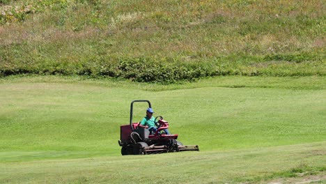 a lawnmower cutting grass in a field