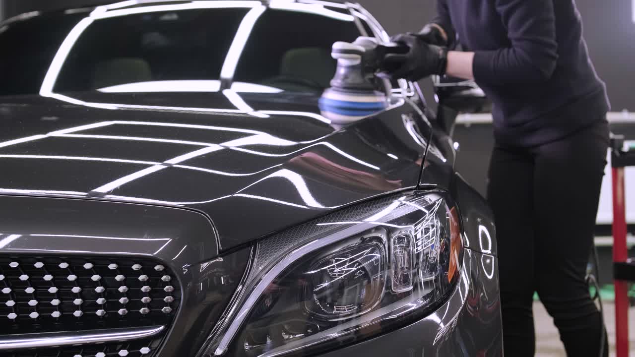 페인트 복원을 위해 기계와 폴리셔를 사용하는 전문 자동차 디테일링.